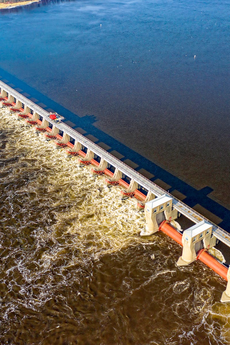 Drone shot capturing the Alma Dam's architectural structure on the Mississippi River in daylight.